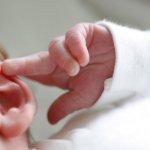 Newborn touching his ear